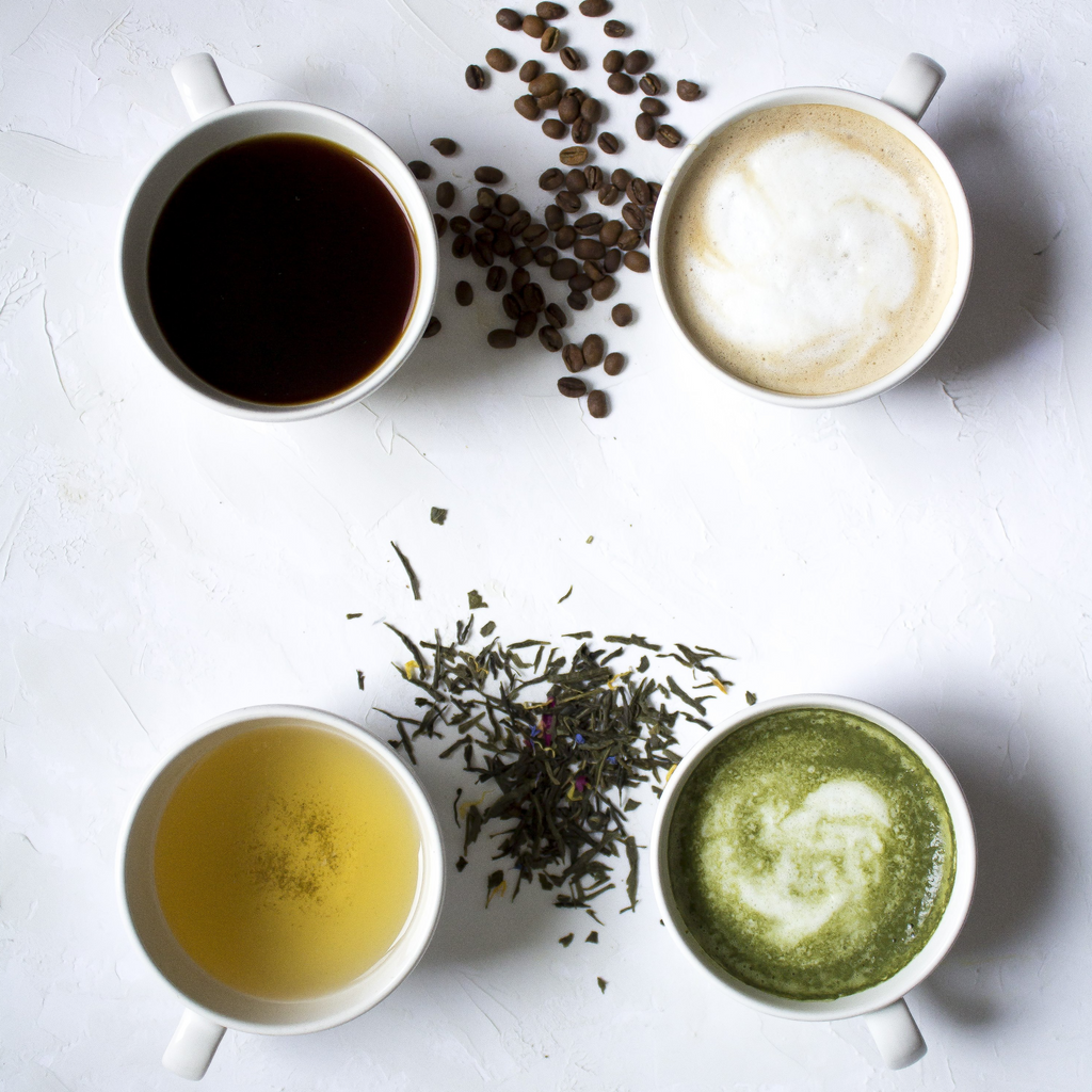 Cups with hot beverages, one side with tea, the other side with coffee