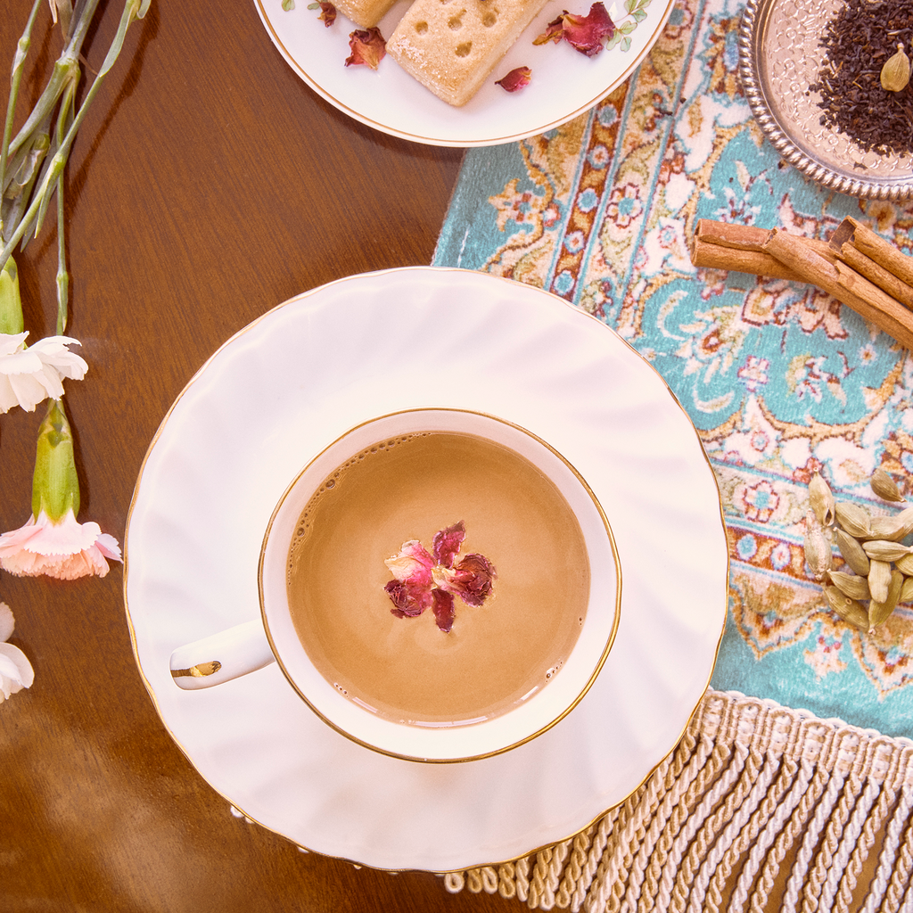 Classic Masala chai in a cup with biscuits and spices on the table