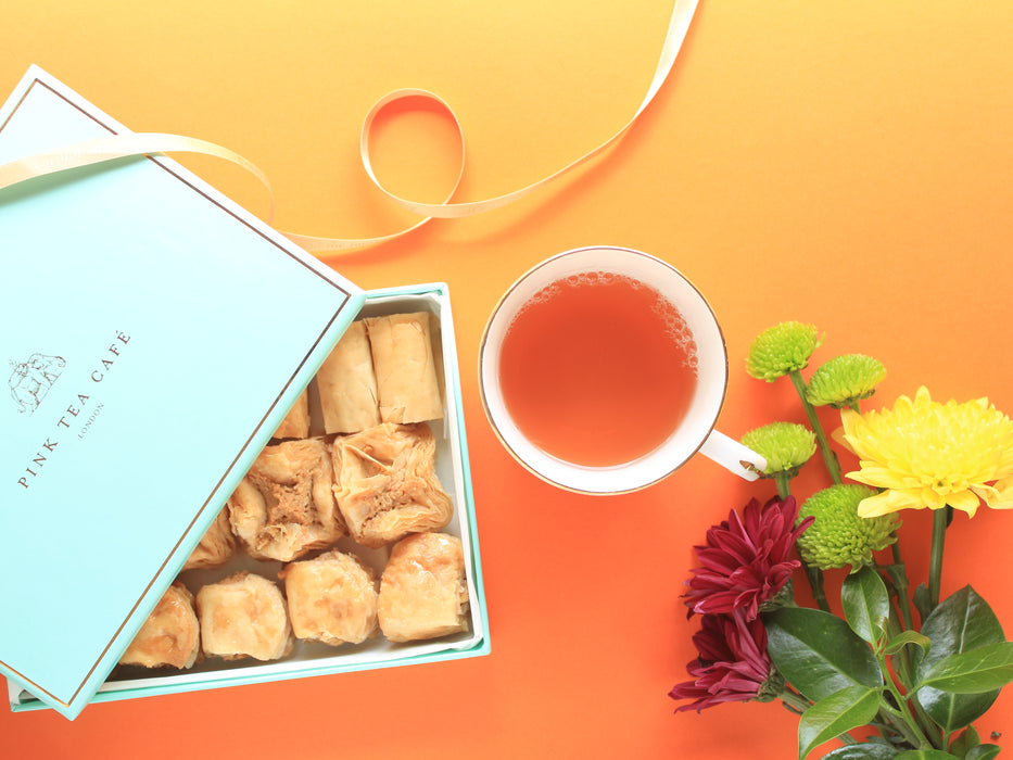 The wonderful peachy colour of the brewed China Pink Tropics with the delicious baklava in a premium gift box and golden ribbon