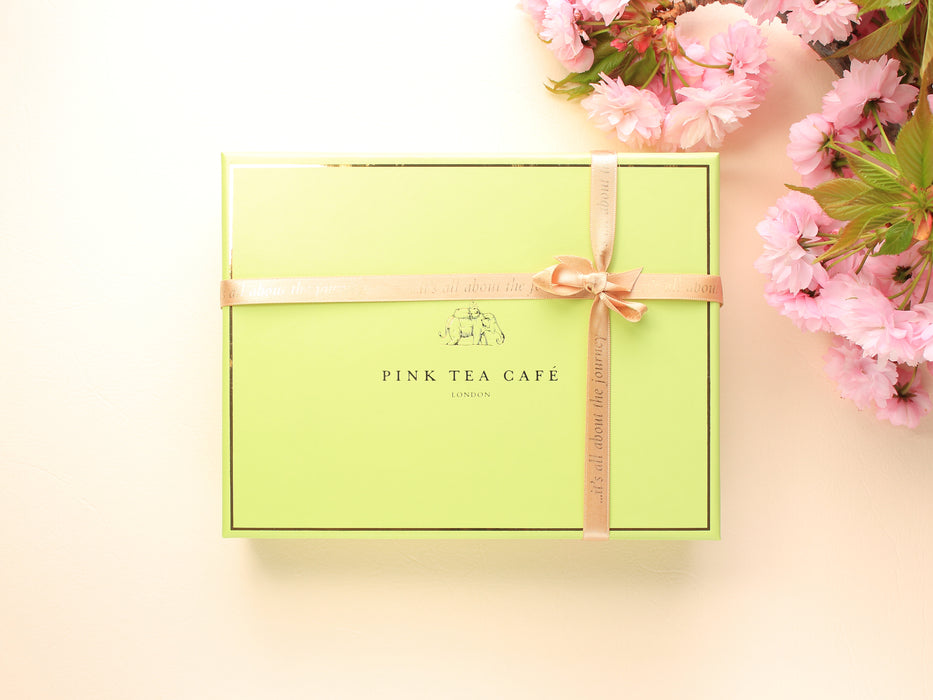Premium, green gift box with golden ribbon, decorated with pink flowers
