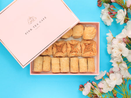 Luxury branded, pink box with delicious regular baklava pieces, decorated with white flowers