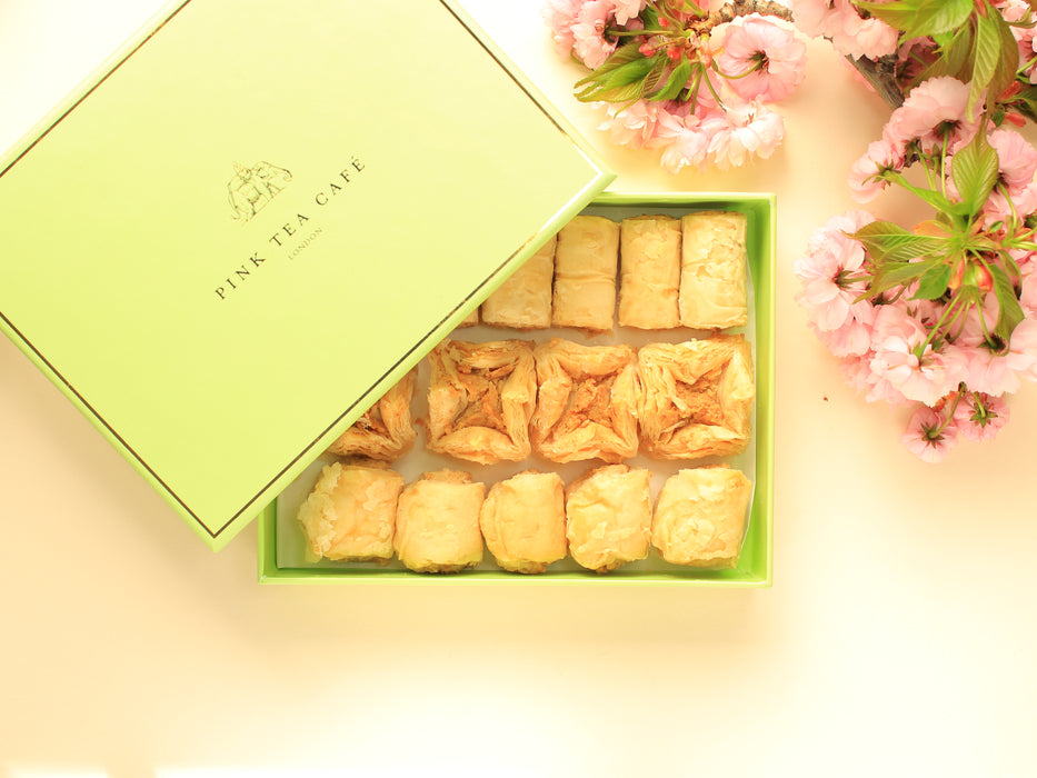 Premium, green gift box filled with vegan baklava pieces, decorated with pink flowers